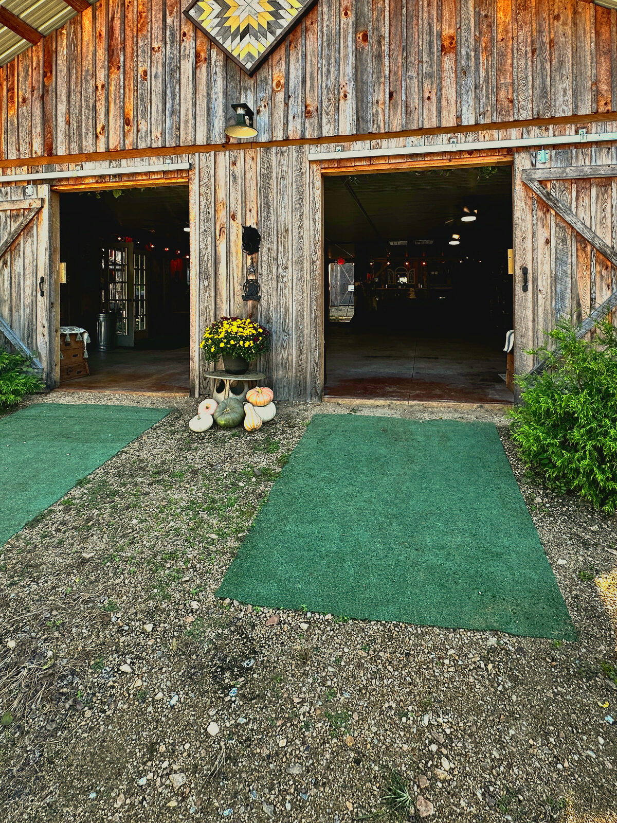The barn front with its doors open and a hand-painted barn quilt at Riverside Farm